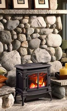 a fire place sitting in front of a stone wall