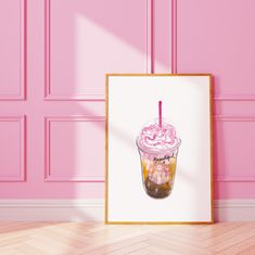 a pink wall with a framed photograph of an iced coffee drink