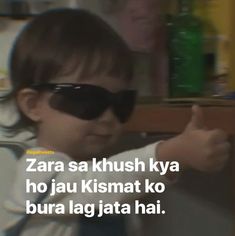 a young child wearing sunglasses giving the thumbs up