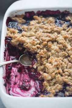 blueberry cobbler in a white dish with a spoon