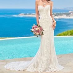 a woman standing in front of a pool wearing a wedding dress