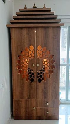 a wooden cabinet with an intricate design on the front and side doors, in a room