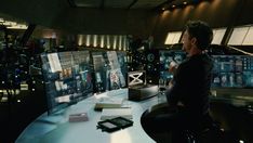 a man sitting at a desk in front of computer monitors