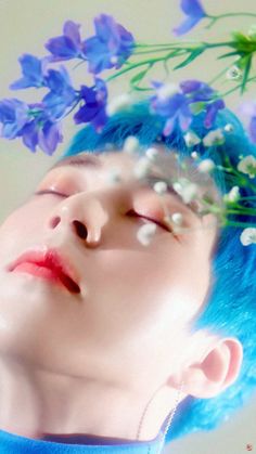 a woman with blue hair and flowers on her head is looking up at the sky