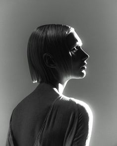 a black and white photo of a woman's profile with her hair pulled back