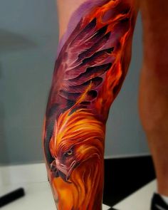 a man's leg with an orange and red bird tattoo on his left arm