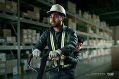 a man in a warehouse holding a forklift