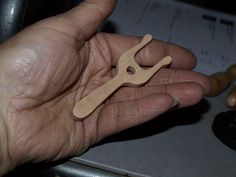 a person holding a small wooden object in their hand