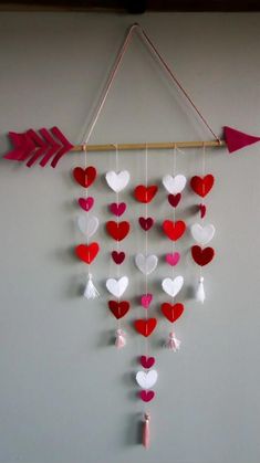 an arrow and heart mobile hanging on the wall