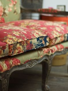 an upholstered bench with floral fabric on it