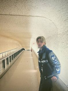 a young boy standing on an escalator in a subway station looking at the camera