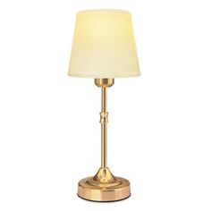 a gold table lamp with a white shade