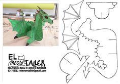 an image of a paper cut out of a green dragon with wings and tail sitting on top of a table