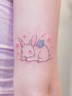 a small bunny tattoo on the right side of the leg, with hearts and stars around it