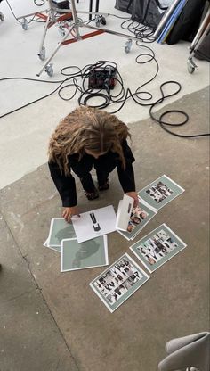 a person kneeling down on the ground looking at pictures