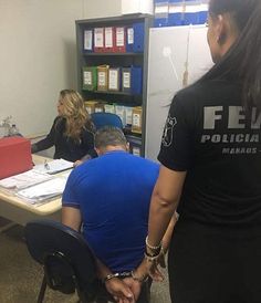 three people sitting at a table in an office