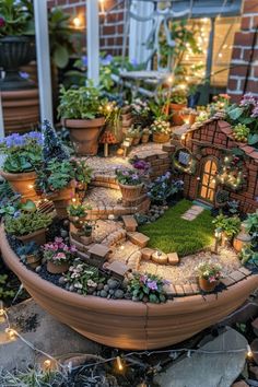 an outdoor garden with potted plants and fairy lights on the ground in front of a brick building