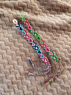 two colorful bracelets laying on top of a blanket