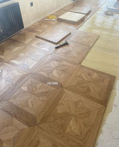 wood flooring being laid out on the ground in a room with hard wood floors