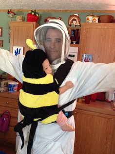 a man in bee costume holding a baby