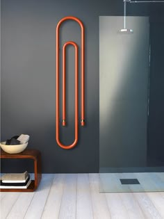 a bathroom with a large orange tube on the wall next to a stand up shower