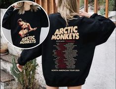 a woman wearing an arctic monkeys sweatshirt