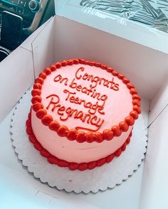 a birthday cake in a box with congratulations written on the frosting and red icing