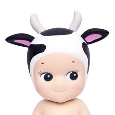 a small toy cow with horns on it's head sitting next to a white background