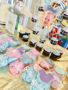 a table topped with lots of cupcakes covered in frosting