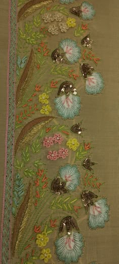 an embroidered fabric with flowers and leaves on the side, along with sequins