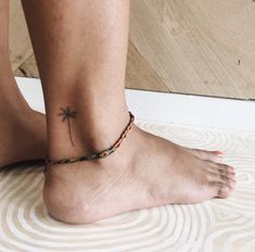 a person with a small tattoo on their ankle and foot is sitting on the floor