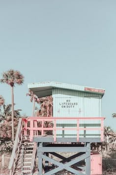 a lifeguard stand on the beach with palm trees