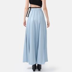 Step into effortless elegance with the Solace Vegan Leather Pleated Maxi Skirt in powder blue. With a hidden zip closure and stylish golden embellishments, this skirt combines sophistication with a touch of luxury. The lightweight fabric drapes beautifully, offering a relaxed yet structured fit with just the right amount of stretch for comfort and durability. The vertical hand-pleating creates a flattering silhouette by elongating the lower body. Perfect for stylish occasions where comfort is ke Full Length Pleated Skirt For Spring, Chic High-waist Blue Maxi Skirt, Chic High Waist Blue Maxi Skirt, Light Blue Skirt For Workwear, Light Blue Skirt For Work, Spring Formal Wide-leg Maxi Skirt, Light Blue Flowy Skirt For Party, Flowy Light Blue Party Skirt, Chic Blue Wide Leg Culottes