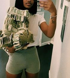 a woman taking a selfie with her cell phone and money wrapped around her waist