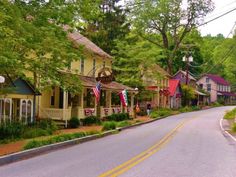 an empty street lined with small houses and flags on the side of it's sides