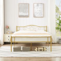 a bedroom with white walls and wooden flooring has a gold metal bed frame in the middle