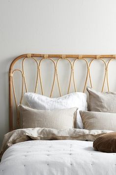 a bed with white linens and pillows on top of it next to a wall