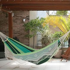 a green and white hammock hanging from a pergolan