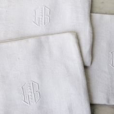 three white towels with monogrammed initials on them