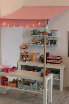 a child's playroom with toys and shelves on the wall, including a pink canopy