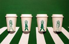 three starbucks cups with green designs on them are lined up in front of a green background