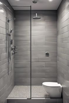 Modern bathroom with a walk-in shower featuring grey tiles and a rain showerhead next to a wall-mounted toilet. Wet Room Bathroom Small Layout, Small Wet Room Ideas, Wet Room Tiles