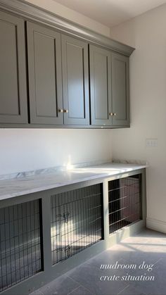 an empty kitchen with grey cabinets and white counter tops, is pictured in this image