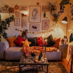 a cat sitting on top of a couch in a living room next to a table