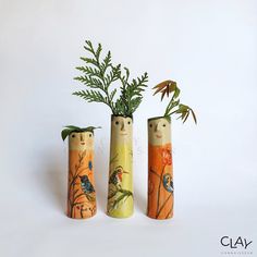 three vases with plants in them on a white surface