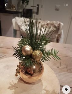 a gold vase filled with ornaments on top of a wooden table