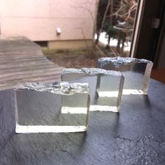 three pieces of metal sitting on top of a table