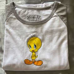 Brand New Tweety Longs Sleeve T-Shirt Tweety Bird Shirt, Unisex White T-shirt With Funny Print, White Short Sleeve Top With Cartoon Print, Fun White Tops With Cartoon Print, White Fun Tops With Cartoon Print, Fun White Top With Cartoon Print, Playful White Cotton T-shirt, White Top With Cartoon Print, Trendy White Cartoon Print Top