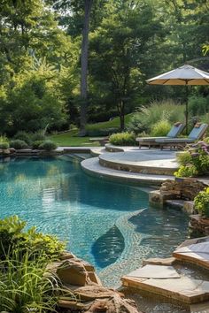 an outdoor swimming pool surrounded by lush green trees and shrubs with umbrellas over it