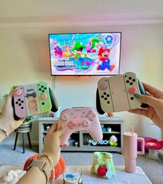 two people holding nintendo wii game controllers in front of a flat screen tv with mario kart on it